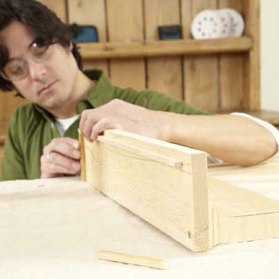 man installing a stop rail on a shelf