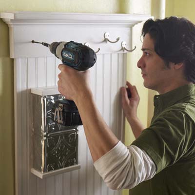 hands installing wall organizer to wall