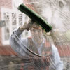 man scrubbing window with a strip applicator