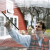 man wiping soapy window pane with a squeegee