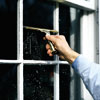 man using a customized squeegee to wipe soapy water from smaller panes of glass