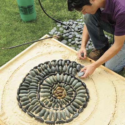 Mark Powers making a test version of his pebble mosaic in a miniature sandbox