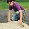 Mark Powers leveling out dry concrete mix with a scrap piece of 2x4