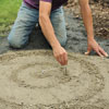 Mark Powers marking out the radius of his pebble mosaic with two nails attached to a piece of string