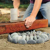 Mark Powers setting and leveling the stones by using a rubber mallet and scrap 4x4 in his pebble mosaic