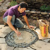 Mark Powers spreading topping mix over his pebble mosaic