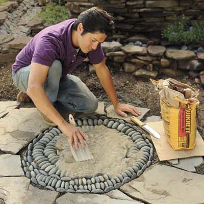 Mark Powers spreading topping mix over his pebble mosaic
