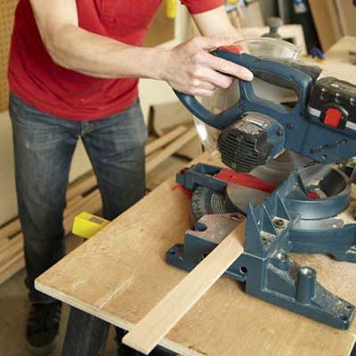 Mark Powers uses a miter saw to cut pieces for a dog crate
