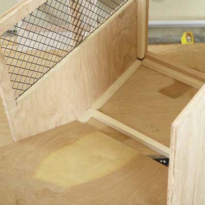 Mark Powers inserts the floorboard into the bottom of a dog crate