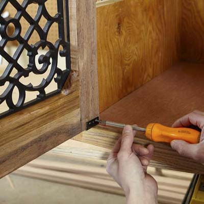 Mark Powers attaches the face frame to the rest of a dog crate