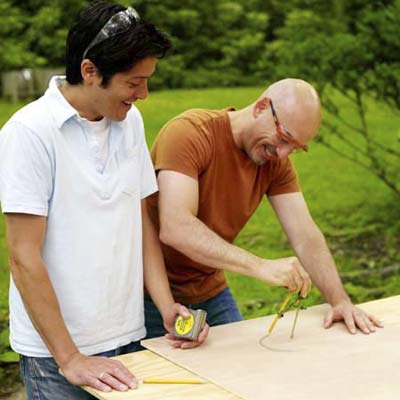 two men tracing circle for cornhole game board