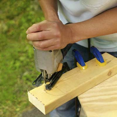 man making legs for cornhole game board