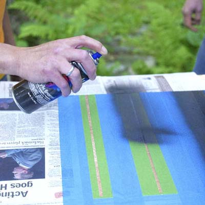 people taping off and painting the lines while building a ricochet game board