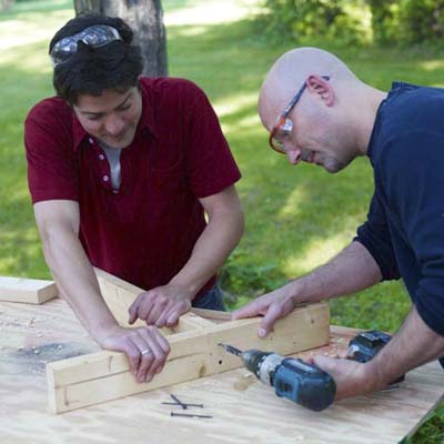 two men assembling stand for ladder golf