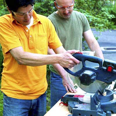 people cutting the sides ends and center rail while building a ricochet game board