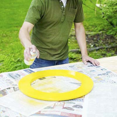 man spray painting wood ring for shishkaball game