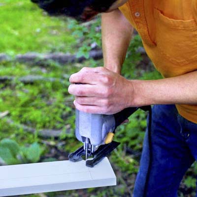 people cutting out the notch while building a ricochet game board