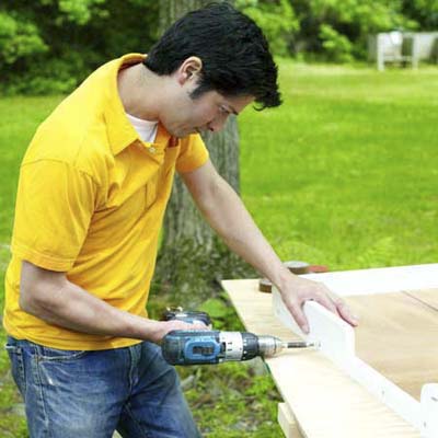 people attaching the sides while building a ricochet game board