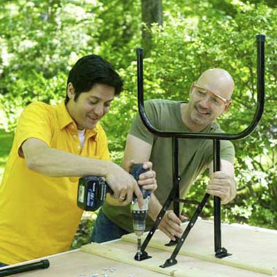 people installing the legs while building a ricochet game board