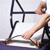 man reinserting spreader bar of patio chair with replaced sling