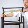 man stretching a vinyl strap across outdoor patio chair frame
