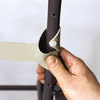 man securing vinyl strap onto outdoor patio chair frame