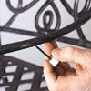 man touching up paint on outdoor patio chair frame