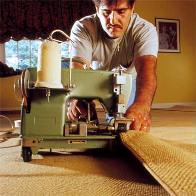 person finishing the edges to demonstrate how-to install carpet