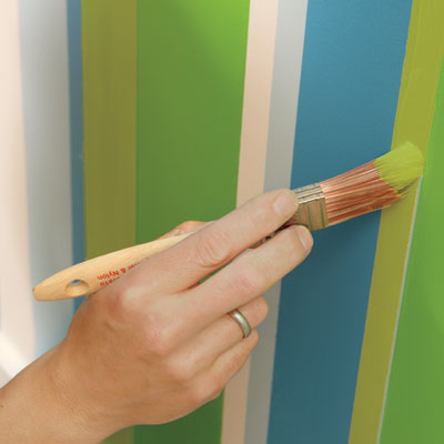 touch up the stripes to finish painting a striped wall
