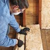 man cutting insulation batting