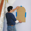 man placing wall niche template on wall