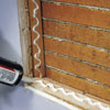 man applying caulk to the inside of wall niche opening