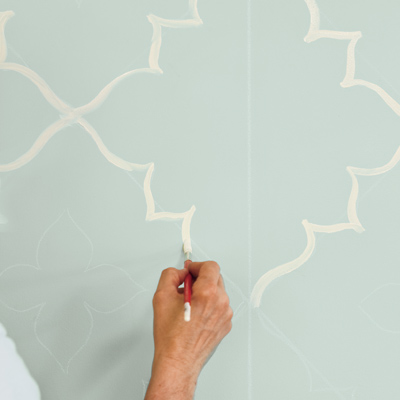 man painting moroccan wall design