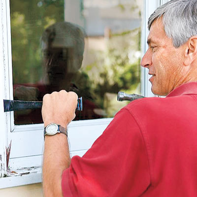 man removing side casings of rotted window sill