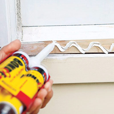 man applying adhesive for installing new windowsill