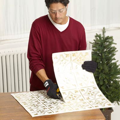 Mark Powers cuts squares of tin ceiling for the sides of the x-mas tree box stand