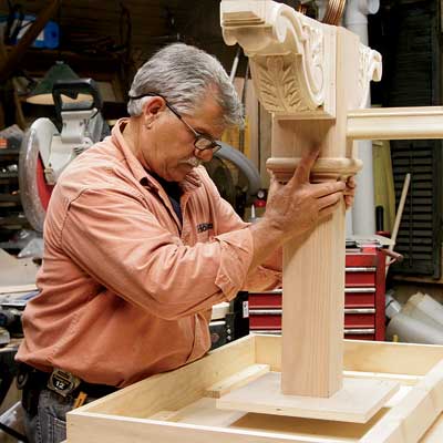 Tom Silva positions the leg assembly to the underside of the table top for a trestle table