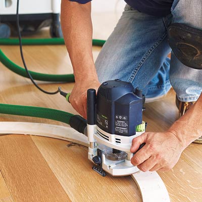 using a router to make a circular cut in the floor to accommodate a floor medallion