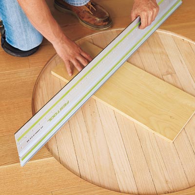 using a straightedge and some scrap flooring to check that the subfloor is flat and even