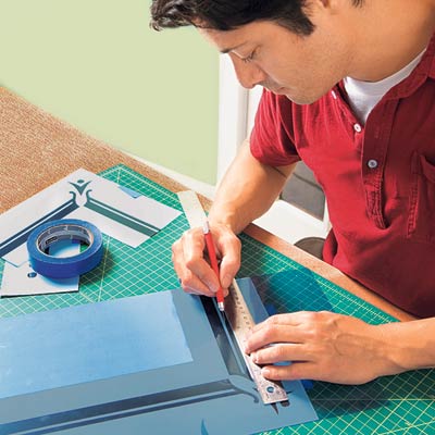 Mark Powers cuts the straight lines of the stencil pattern with an X-Acto knife and a straightedge