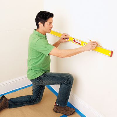 using a level to mark the wainscot layout