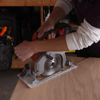 man using circular saw to make poker table