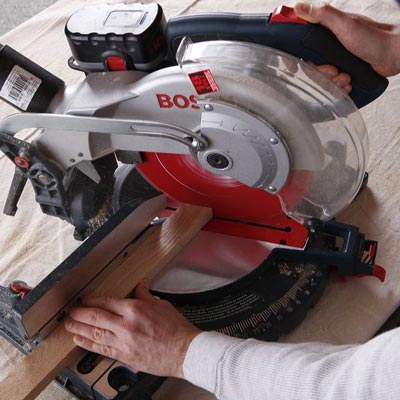 man using miter saw to construct poker table