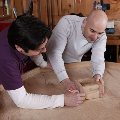two men assembling and marking collar on poker table
