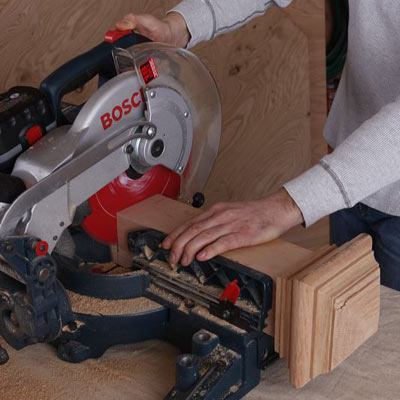man using miter saw to cut poker table stand