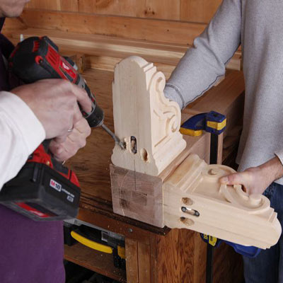 man drilling pilot holes in feet of poker table