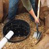 shoveling rounded stones into the dry well hole