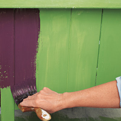 applying a top coat of purple paint over faux crackle for a kitchen island