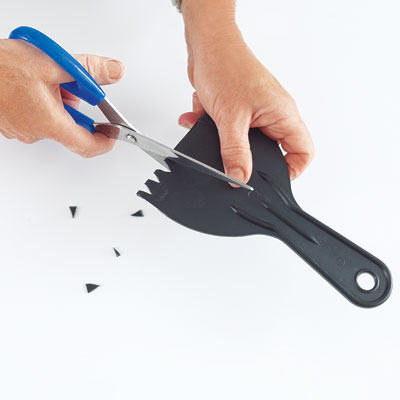 cutting notches in a plastic putty knife for the combing tool