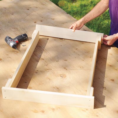 Mark Powers fastens pieces for a hypertufa table with a drill/driver